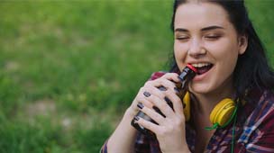 Woman risking chipped tooth in Phenix chewing on bottle cap