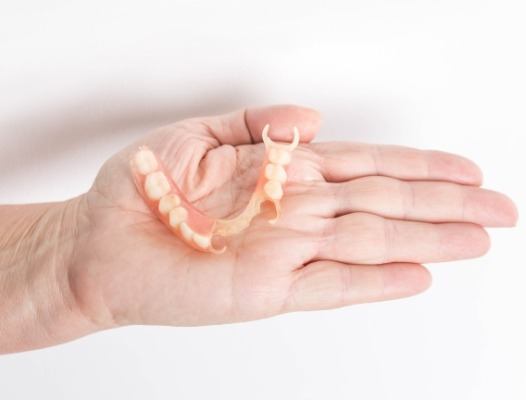 Hand holding a partial denture