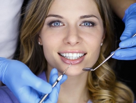 Woman receiving dental checkup and teeth cleaning