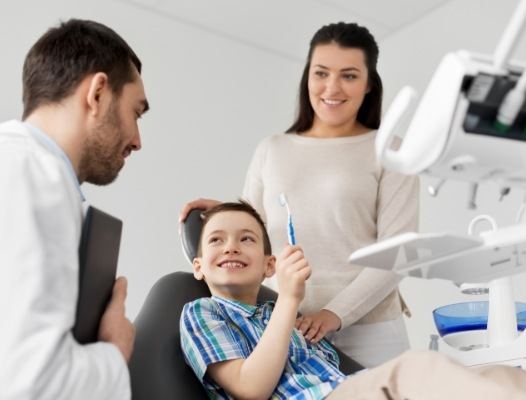 Mother and child talking to dentist during dental treatment
