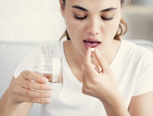 Woman taking oral conscious dental sedation pill
